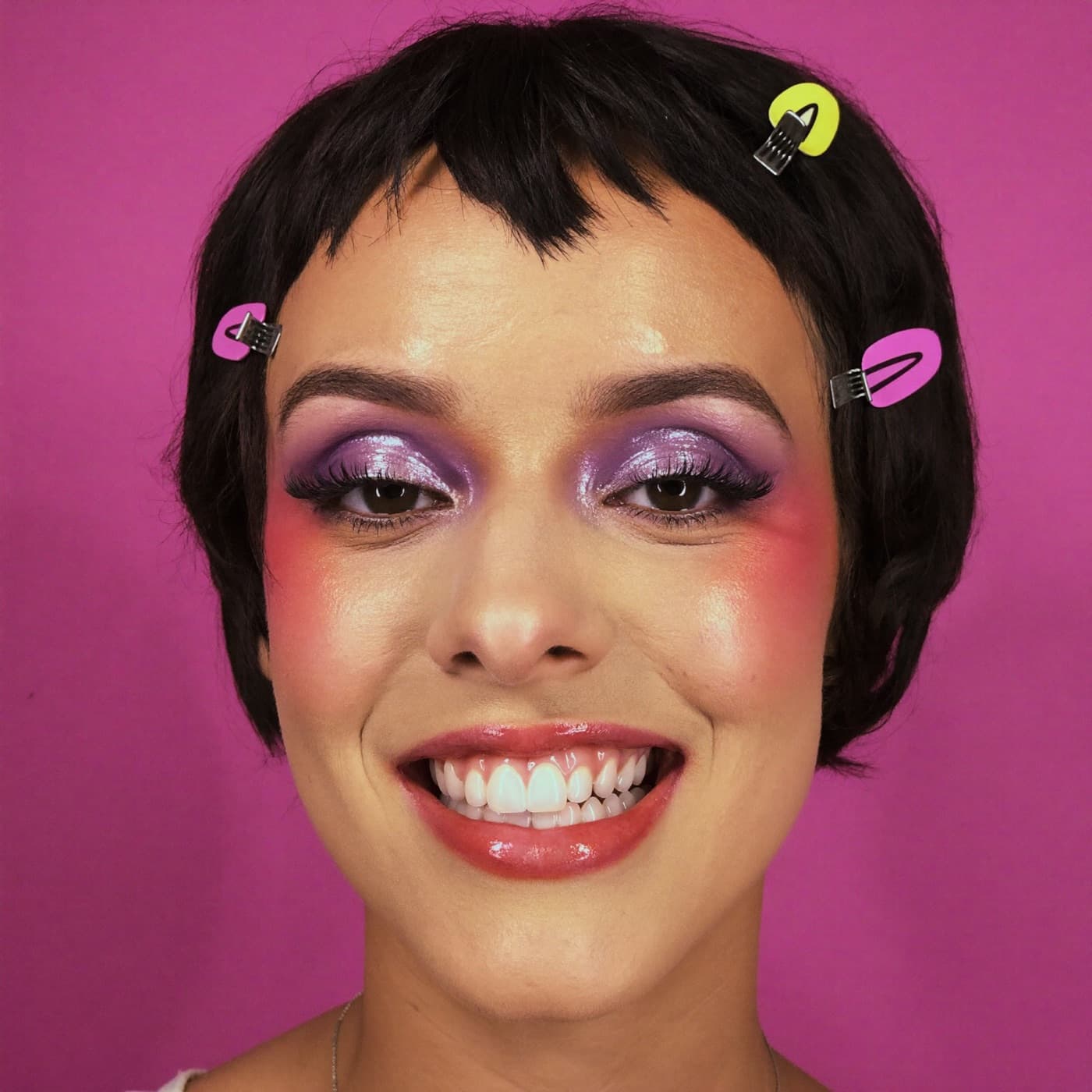 a makeup creator with lilac eyeshadow on a pink backdrop